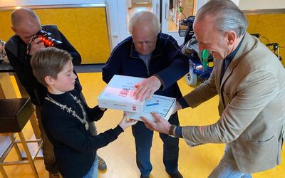 De uitreiking van het Hop-On Hop-Off-spel in Huiskamer Oosterhout. Met kinderburgemeester Thijmen Wien, Theo Voorn en Marc Jansen.  © Woonstichting Valburg